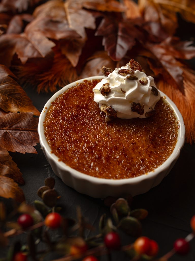 Pumpkin Spice Creme Brulee in a dish with whipped cream on top