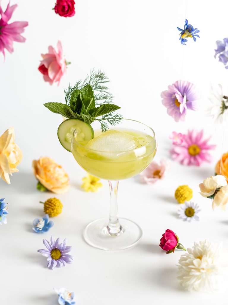 "Speaking of Spring" cocktail in a stemmed glass with flower decor