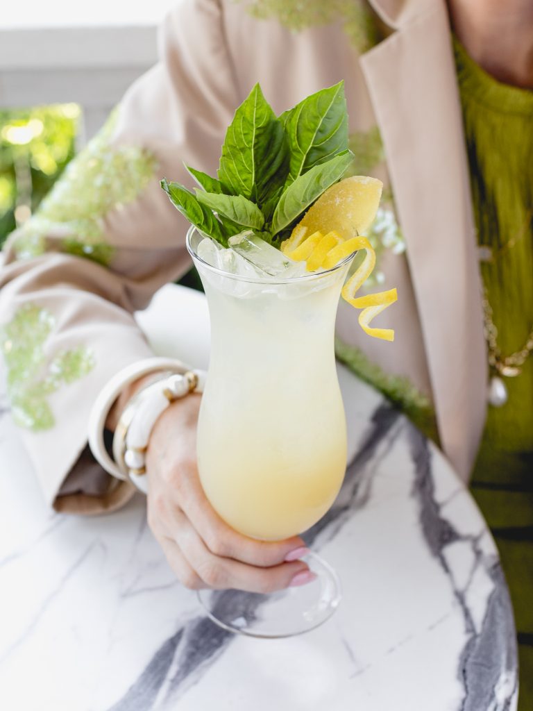 Woman sitting at a table holding a Bougie Water (a Non-Alcoholic drink) in a glass