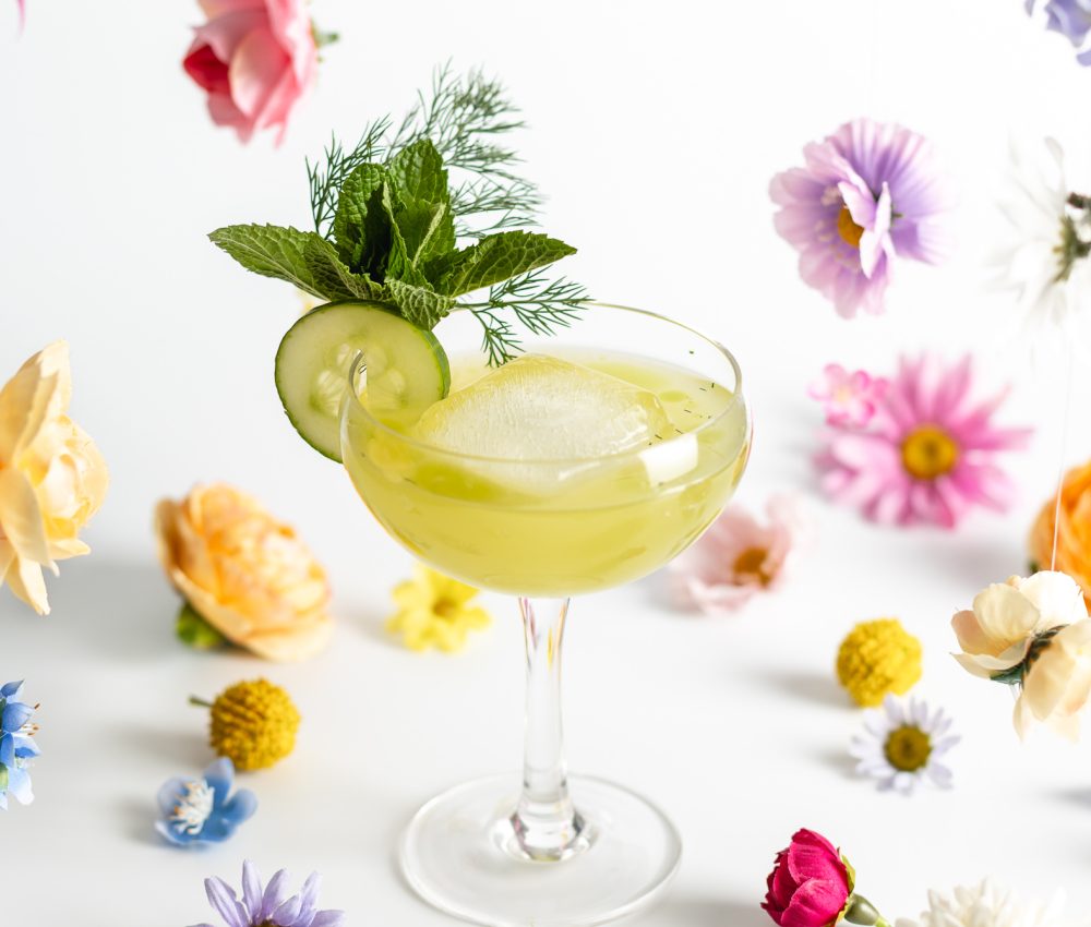 "Speaking of Spring" cocktail in a stemmed glass with flower decor