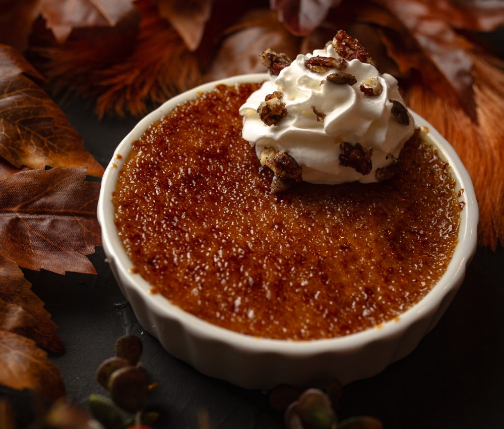 Pumpkin Spice Creme Brulee in a dish with whipped cream on top